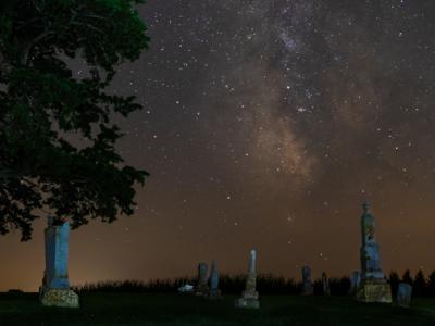 Cemetery at night with milky way taking up the top 2/3rds of the image.