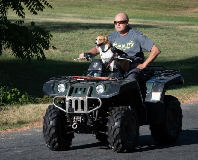 Dog and person on 4-wheeler.
