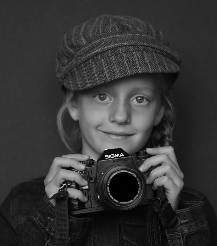 Maker: Sonja Haske Entered in: 2018 November Competition - A People Score: 39 points  1st PlaceJudge's comments: Great expression; works well in black and white; camera and hat brim are a little sharper than the faceMaker's comments: 