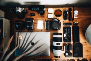 Photography gear and laptop all laid out and shot from above.