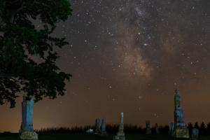 Cemetery at night with milky way taking up the top 2/3rds of the image.