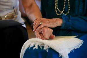 An older person holding the hand of a younger person.